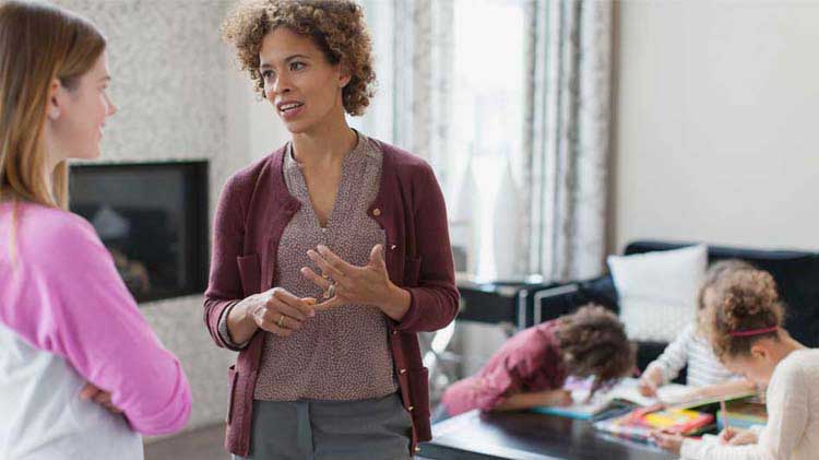 Parent briefing a caregiver — clear instructions and roles improve safety during Halloween activities.